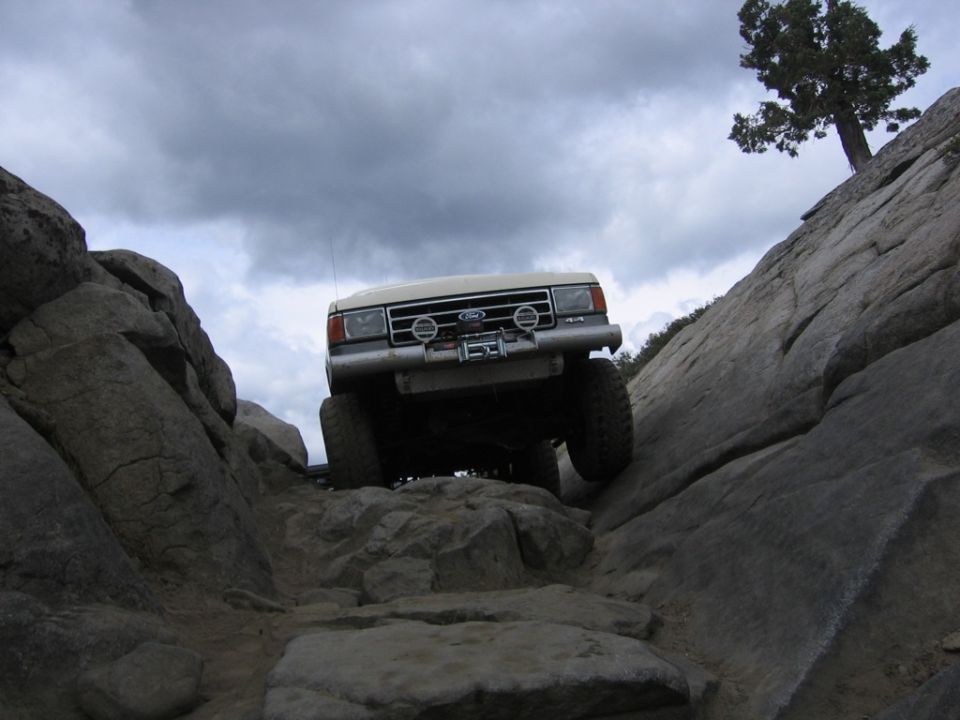 White 1989 Ford Bronco navigating a rocky trail