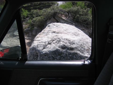 1989 Ford Bronco - A large boulder obstructs the path ahead, viewed from the interior of a vehicle.