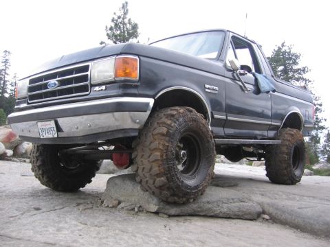 1989 Ford Bronco - This 1989 Ford Bronco is shown off-road with large, knobby tires mounted on black rims.