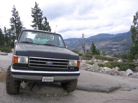 1989 Ford Bronco - 1987 Ford Bronco parked on rocky terrain with a mountainous landscape behind it.