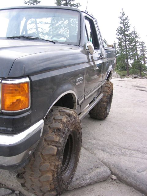 1989 Ford Bronco - This 1989 Ford Bronco is equipped with large off-road tires and appears to be navigating a rocky, outdoor environment.