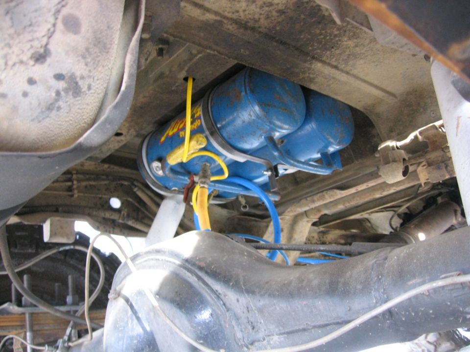 Undercarriage view of dual blue air tanks with yellow and blue hoses
