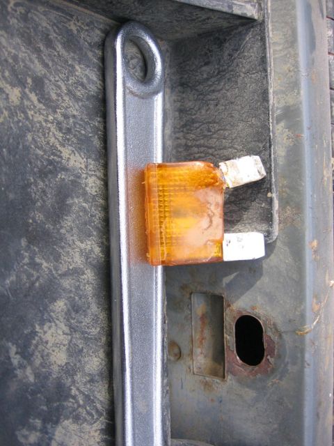 1989 Ford Bronco - Close-up of an orange marker light on a metal bracket.