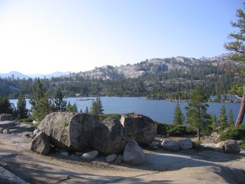 1989 Ford Bronco - A scenic view of a lake surrounded by pine trees and rocky hills on a sunny day.