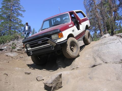 1989 Ford Bronco - This Ford Bronco is navigating a rocky trail, its front end angled upwards.