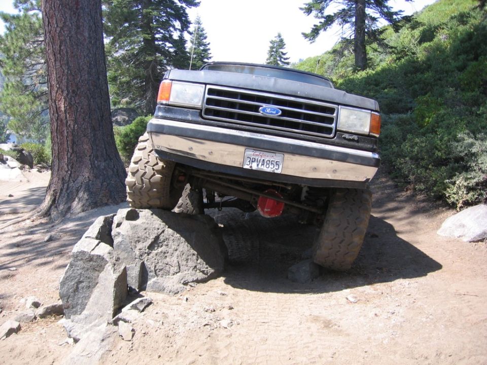 1989 Ford Bronco front 3/4 view off-roading on rocks