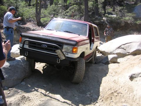 1989 Ford Bronco - This 1989 Ford Bronco is tackling a challenging off-road course with large rocks.