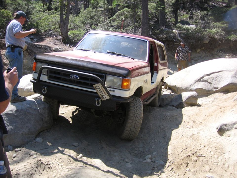 1989 Ford Bronco navigating a rocky trail, front bumper and grille visible