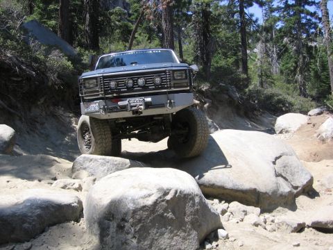 1989 Ford Bronco - This modified Ford Bronco navigates a rocky trail, demonstrating its off-road capabilities.