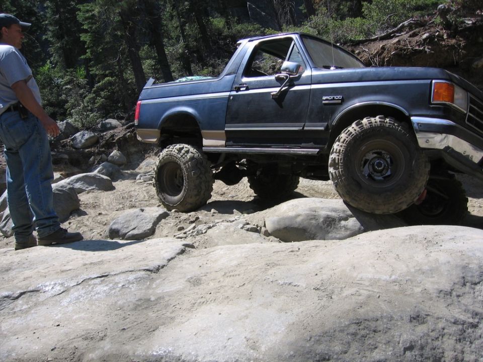 Blue 1989 Ford Bronco navigating rocky terrain