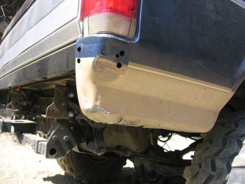 1989 Ford Bronco - The rear bumper and fender show significant damage, indicating a rough history for this SUV.