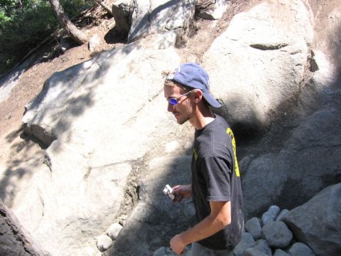 1989 Ford Bronco - A person stands in a natural environment with large rocks and trees.