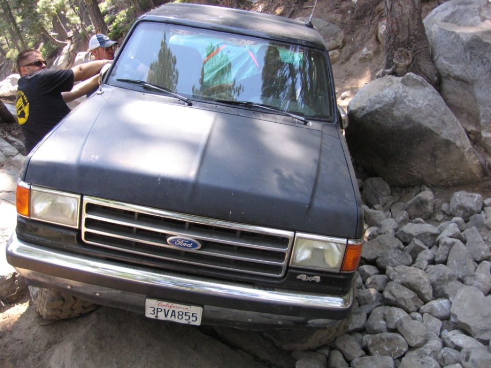 Black 1989 Ford Bronco front view navigating rocky terrain