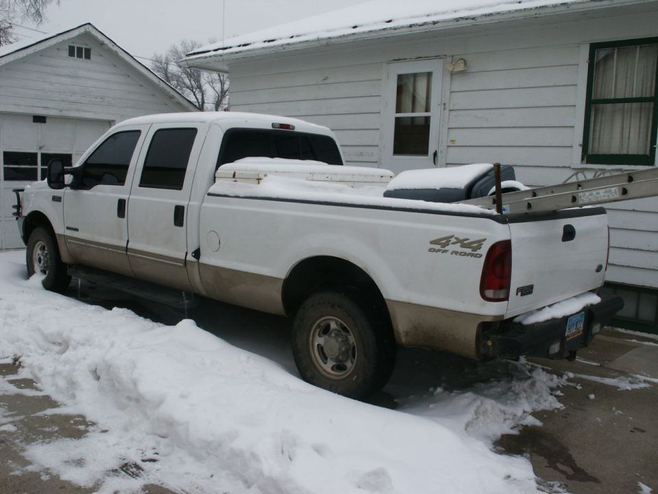 White 2000 Ford F-250 truck with tan lower body panels parked in snow, 4x4 decal visible