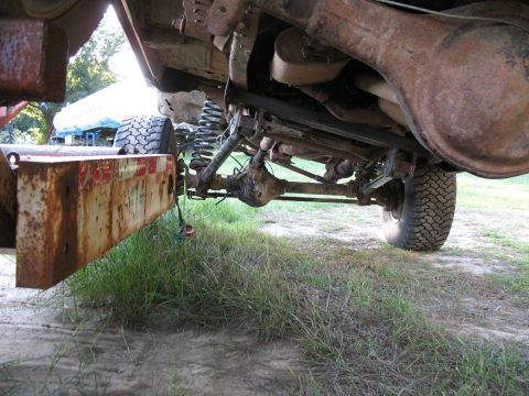 1979 Ford Bronco - The underside of a 4x4 vehicle, showing its suspension and trailer hitch, is captured in this outdoor shot.
