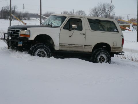 1990 Ford Bronco - This 1990 Ford Bronco is stuck in a snowy ditch with its front tires buried.