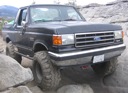 1989 Ford Bronco - This black Ford Bronco is navigating a rocky terrain.