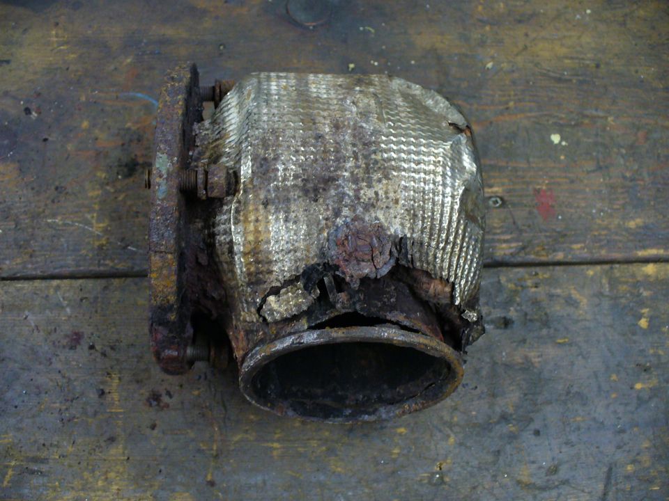 Cut axle tube section with cracked stacked weld beads and a rusted hole in the tube wall