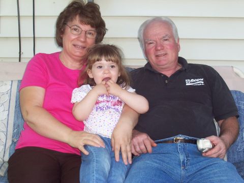 2000 Ford Crown Victoria - A family enjoys a moment together on a porch swing, with the man wearing a shirt with the Mopar logo.