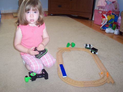 2000 Ford Crown Victoria - A young child plays with a wooden train set on the floor.