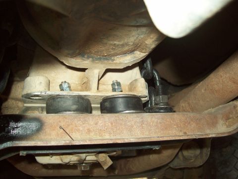1985 Ford Bronco - Underbody view of vehicle suspension components, including rubber mounts and metal brackets.