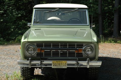 1973 Ford Bronco - A 1973 Ford Bronco is shown from the front, parked outdoors with trees in the background.
