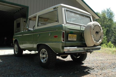 1973 Ford Bronco - The rear view of a green 1973 Ford Bronco, showing its spare tire and license plate.