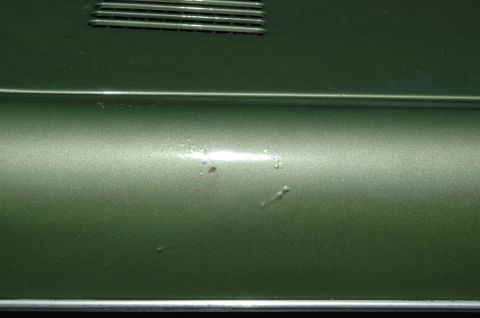 1973 Ford Bronco - Close-up of the side panel on a 1973 Ford Bronco, showing the metallic green paint and a vent detail.
