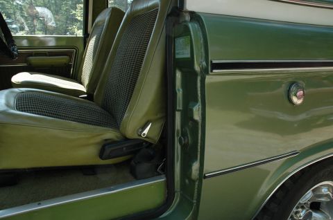 1973 Ford Bronco - Interior view of a 1973 Ford Bronco, its green upholstery and plaid seat inserts.
