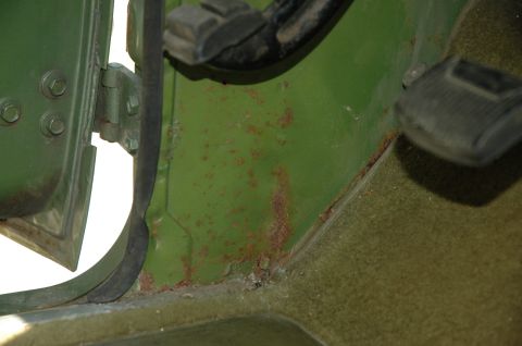 1973 Ford Bronco - Interior view of the driver's side footwell, showing rust and pedals.