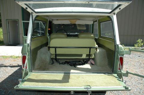 1973 Ford Bronco - Rear view of a 1973 Ford Bronco's interior, showing the seats and cargo area with the tailgate open.