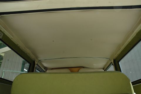 1973 Ford Bronco - The interior of the vehicle shows the headliner and the back seats, with a view out the side windows.