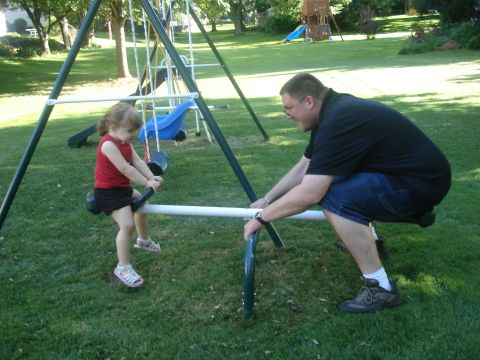2000 Ford Crown Victoria - A father and his daughter enjoy a sunny day on a backyard seesaw.
