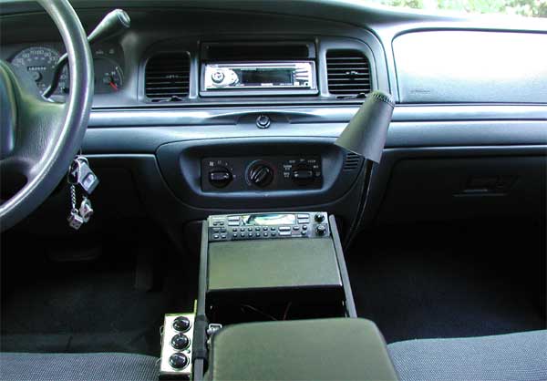 Gray Crown Victoria dash with aftermarket stereo and center console-mounted radio and toggle switches