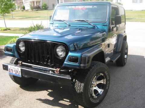 1991 Jeep Wrangler - This teal Jeep Wrangler features a black grille and aftermarket wheels, with text on the windshield reading "It's a Jeep thing... you would…