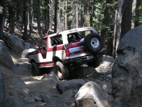 1991 Ford Bronco - This Ford Bronco navigates a rocky trail through a forest.