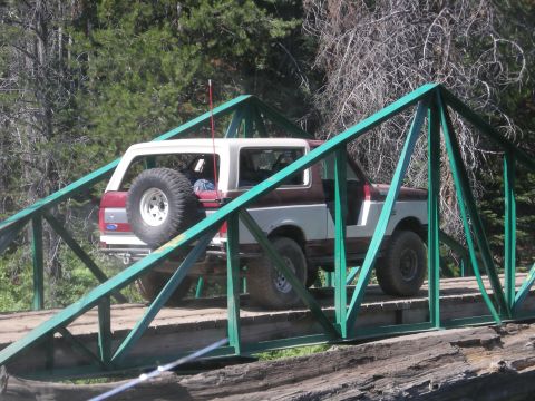 1991 Ford Bronco - Ford Bronco navigates a narrow bridge in a wooded area.