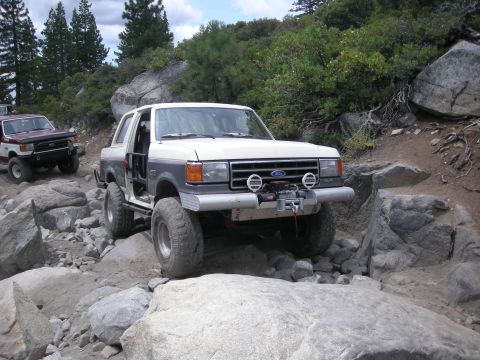 1991 Ford Bronco - This modified 1991 Ford Bronco tackles a challenging off-road trail with large boulders.