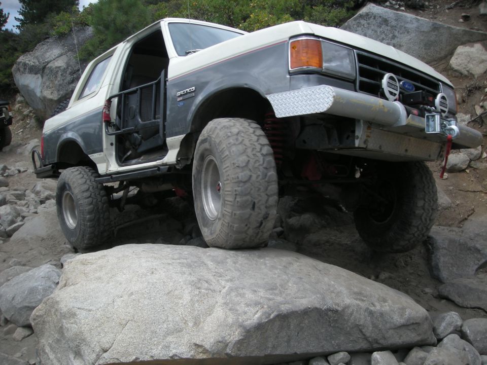 Ford Bronco climbing over rocks on a trail