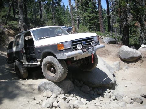1991 Ford Bronco - This 1991 Ford Bronco is shown tackling a challenging off-road trail with large rocks.
