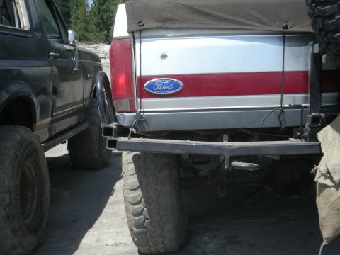 1991 Ford Bronco - Rear view of a 1991 Ford Bronco, showing the iconic Ford badge and a red stripe on the tailgate.