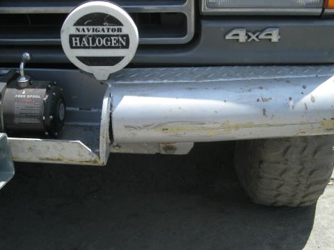 1991 Ford Bronco - Front bumper assembly with winch and auxiliary light, 4x4 badge visible.