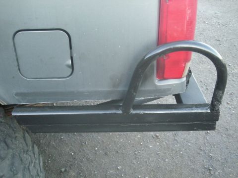 1991 Ford Bronco - Close-up of a gray SUV's rear bumper and taillight assembly, a black protective hoop.