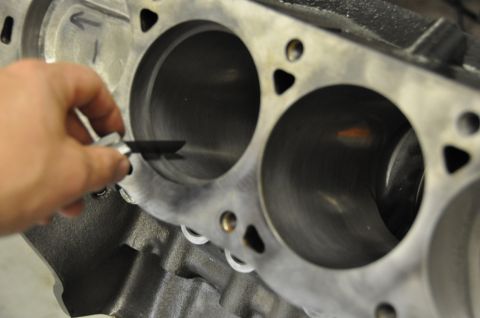 1996 Ford Bronco - A mechanic measures the diameter of a cylinder bore on an engine block.