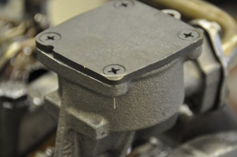 1996 Ford Bronco - This is a close-up view of a metal oil pump housing, secured by four screws.