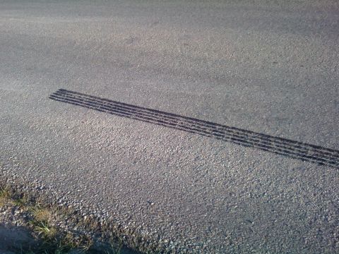 2000 Mercury Grand Marquis - Tire tracks are visible on the asphalt road.