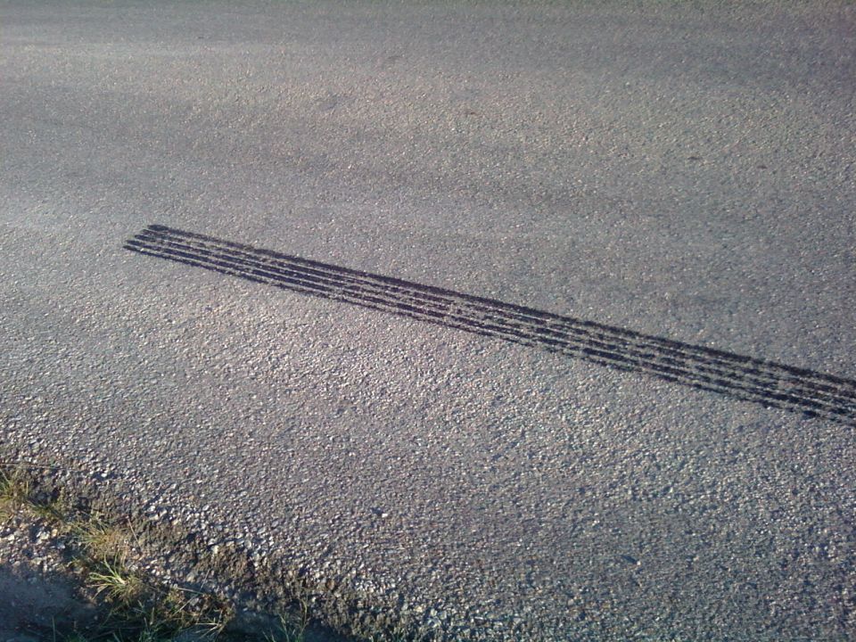 Tire tracks on a paved road surface