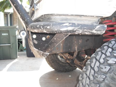 1991 Ford Bronco - A close-up view of an off-road vehicle's rear suspension and bumper, showing modifications and wear.