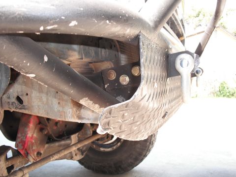 1991 Ford Bronco - Close-up view of the rear bumper and suspension system, diamond plate and a tow hitch.