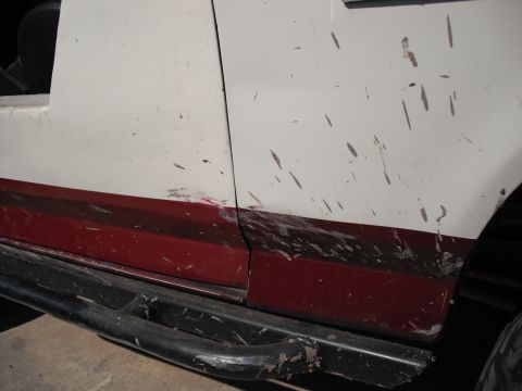 1991 Ford Bronco - The side of an off-road vehicle shows damage and mud splatter from off-roading.